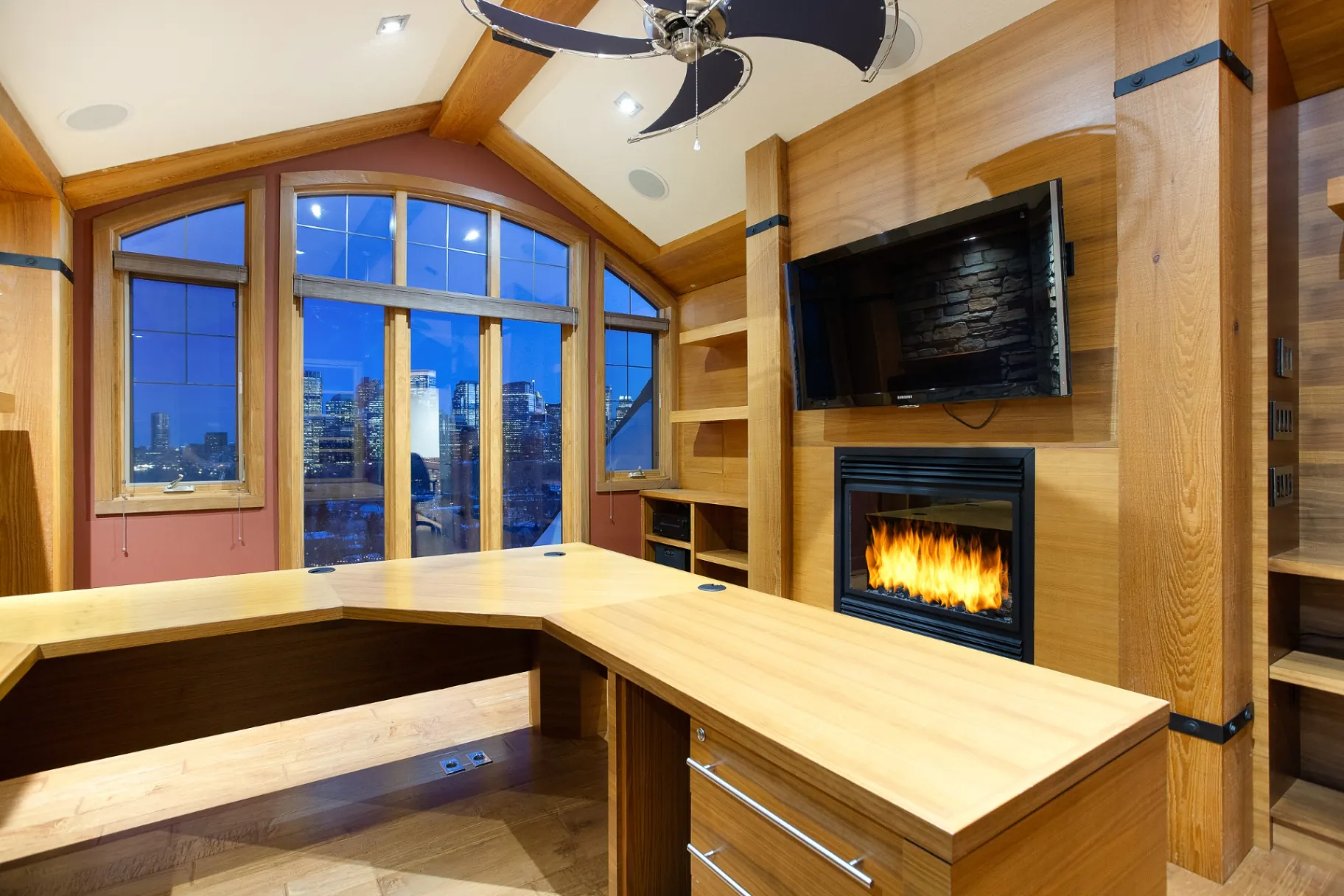 Den with built-in desk, gas fireplace and arched windows